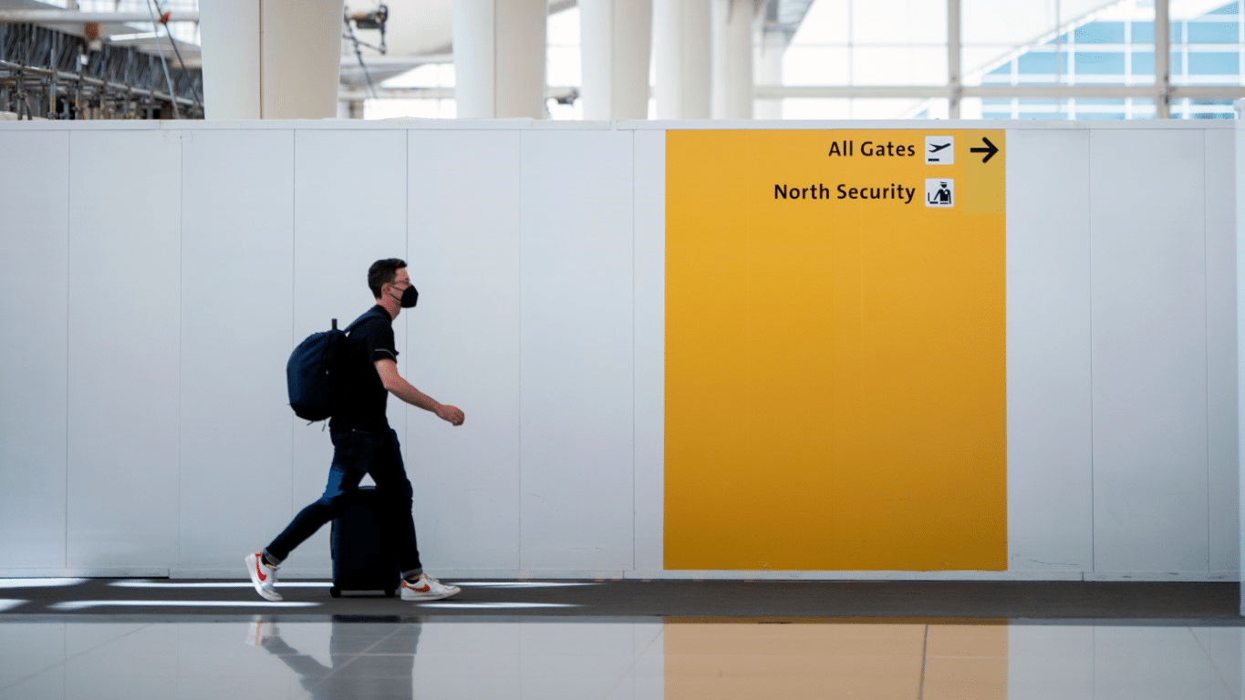 An image of a person walking past a temporary lightweight partition with signage.